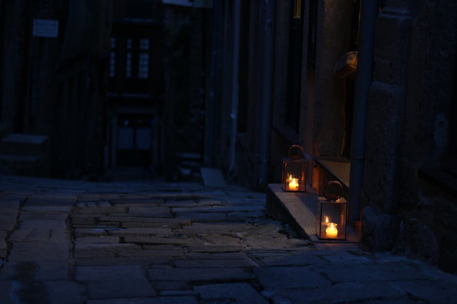 Edinburgh cobblestone close illuminated by warm lanterns at night