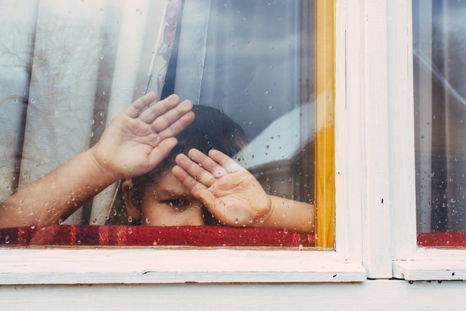 Kids on rainy day looking out Edinburgh window