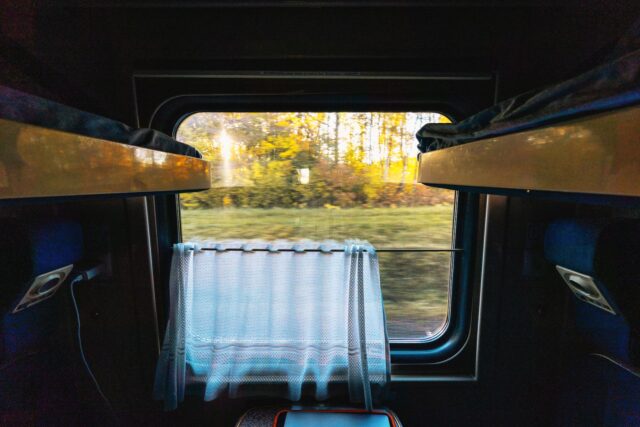 Looking out of a dimly lit train compartment window at first light
