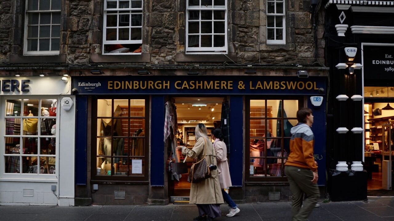 Shoppers passing an Edinburgh cashmere and lambswool shop front