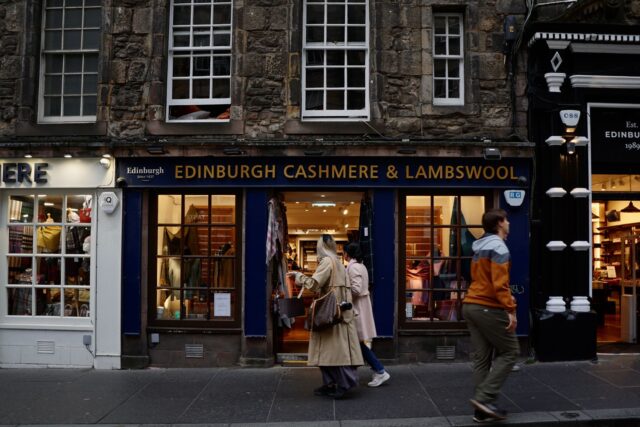 Shoppers passing an Edinburgh cashmere and lambswool shop front