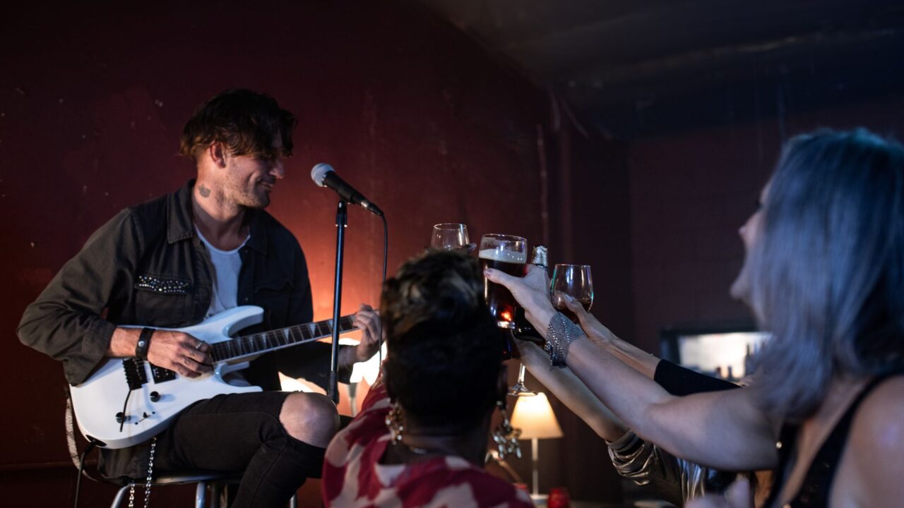 Musician performing live music to a crowd in a small Edinburgh bar
