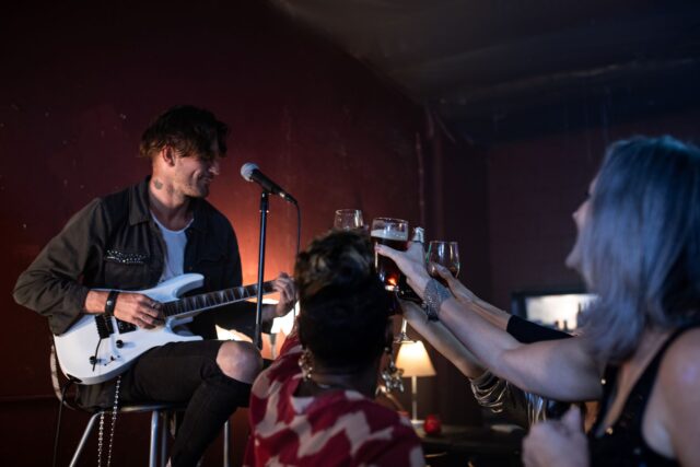 Musician performing live music to a crowd in a small Edinburgh bar