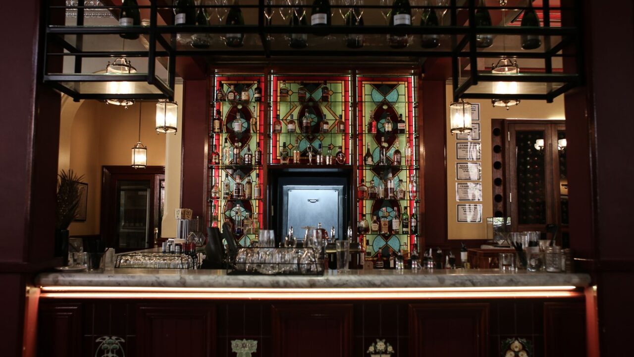 Ornate Victorian pub interior in Edinburgh with stained glass gantry and marble bar