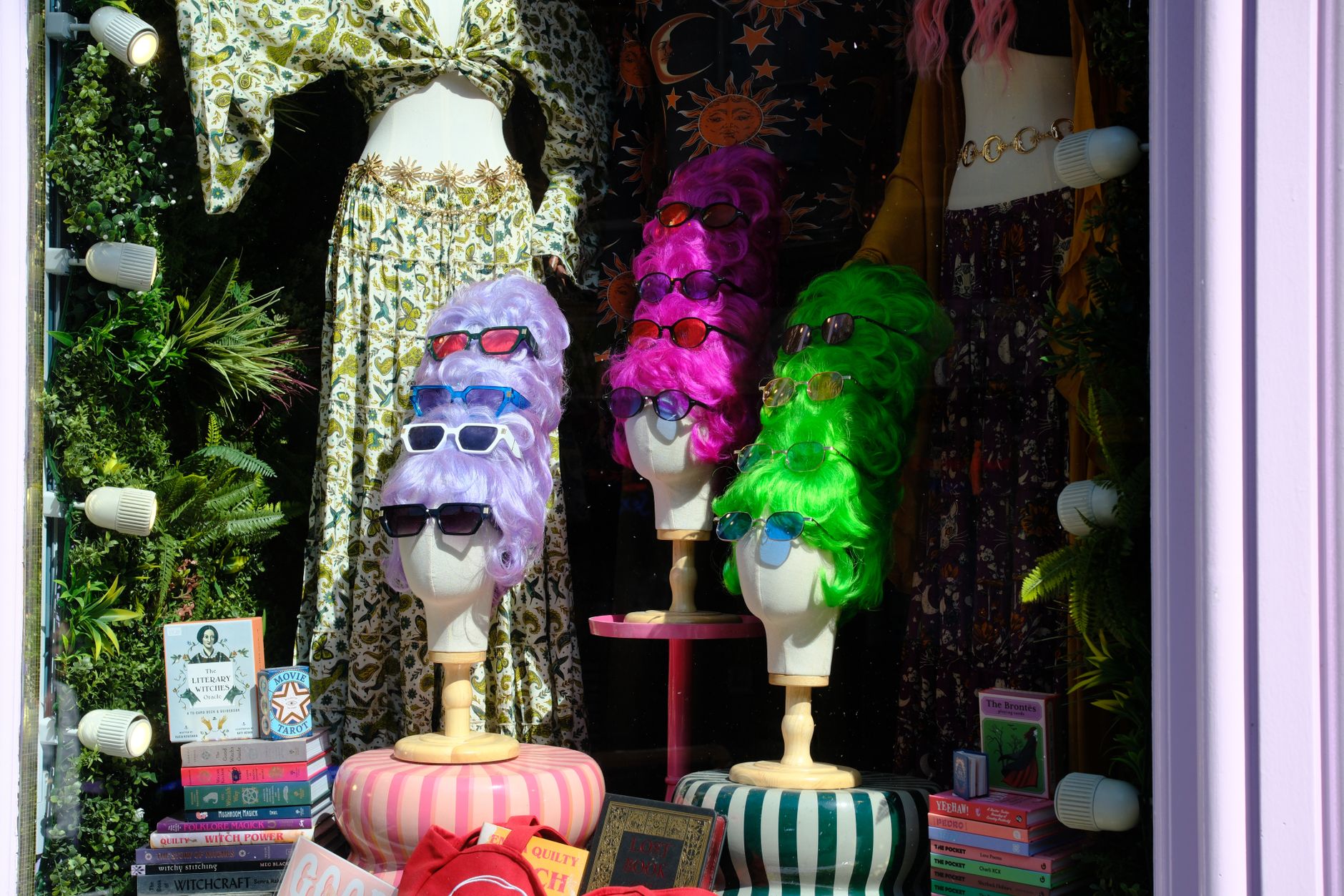 Colourful shop window with mannequin heads in bright wigs and vintage clothing