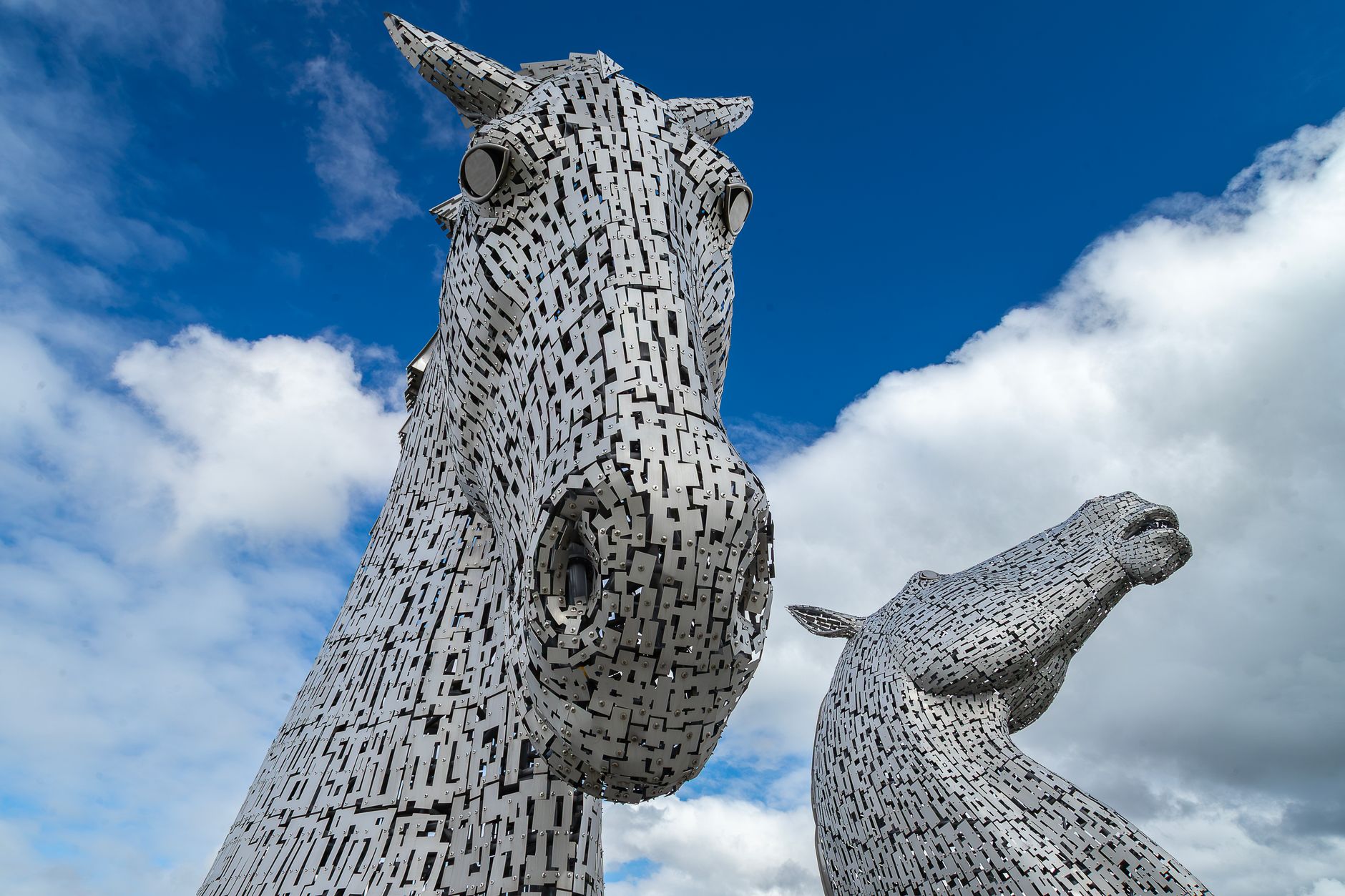 Close-up of the two Kelpies horse-head sculptures in Falkirk against a blue sky