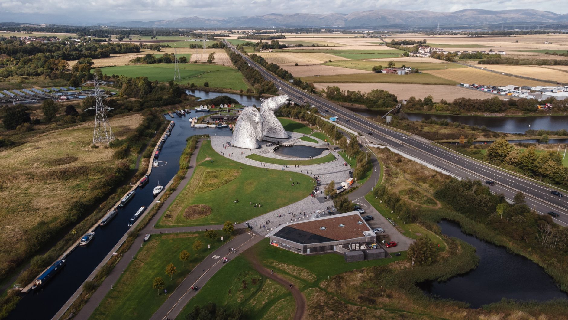 Aerial view of the Kelpies sculptures, canal basin and visitor centre at The Helix in Falkirk