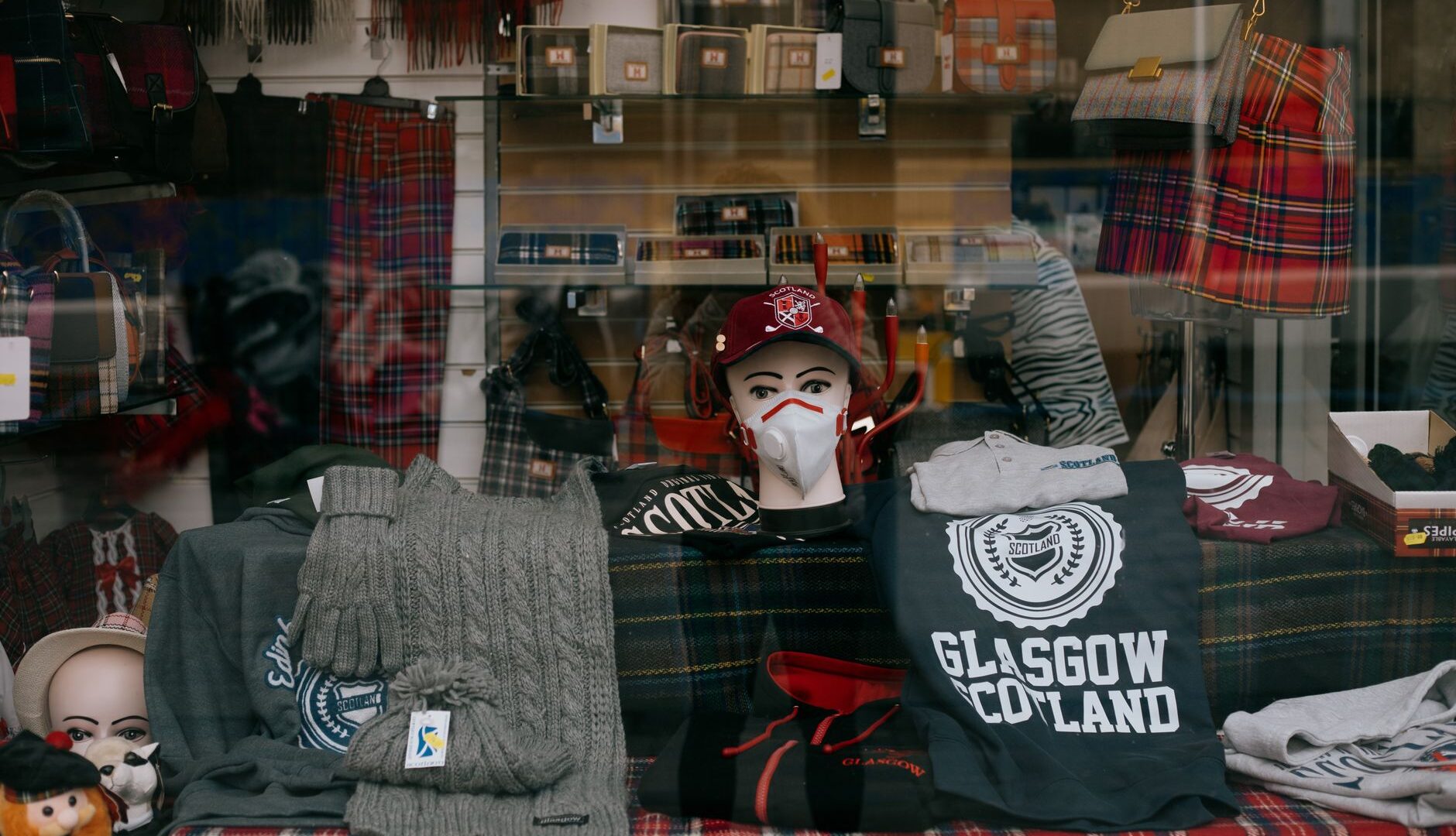Scottish souvenir shop window with tartan scarves, knitwear and slogan t-shirts