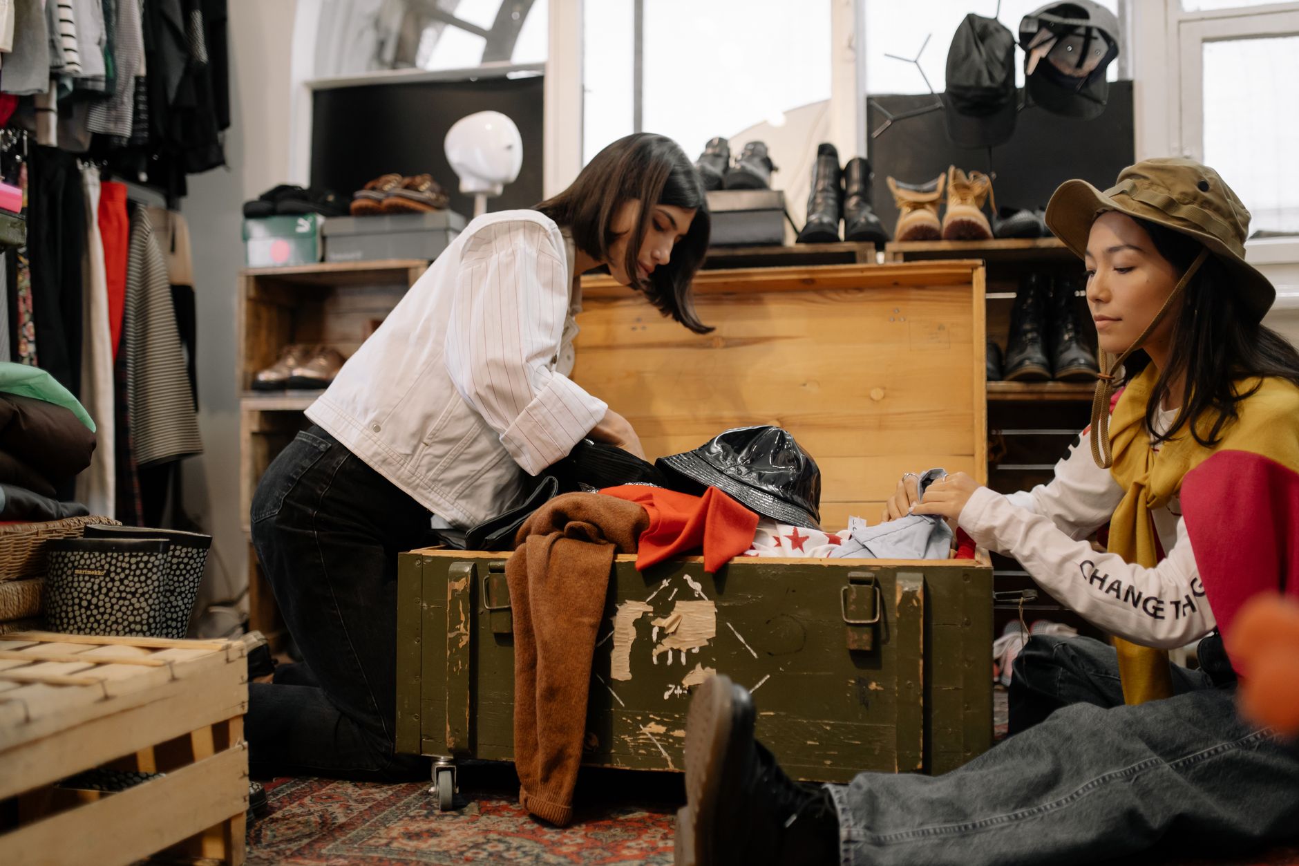 Two people sorting through vintage clothing in a secondhand shop