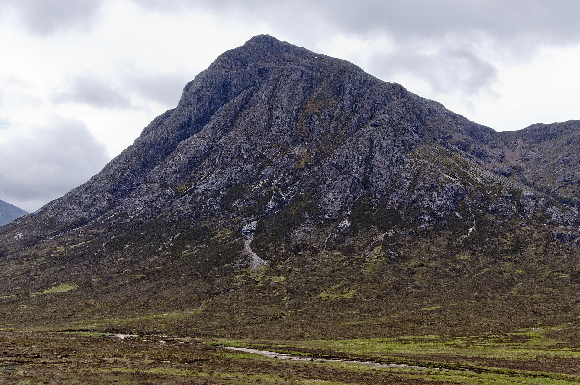 Buachaille Etive Mor towers above open moorland at Glen Coe, its steep grey face cut by rocky gullies.