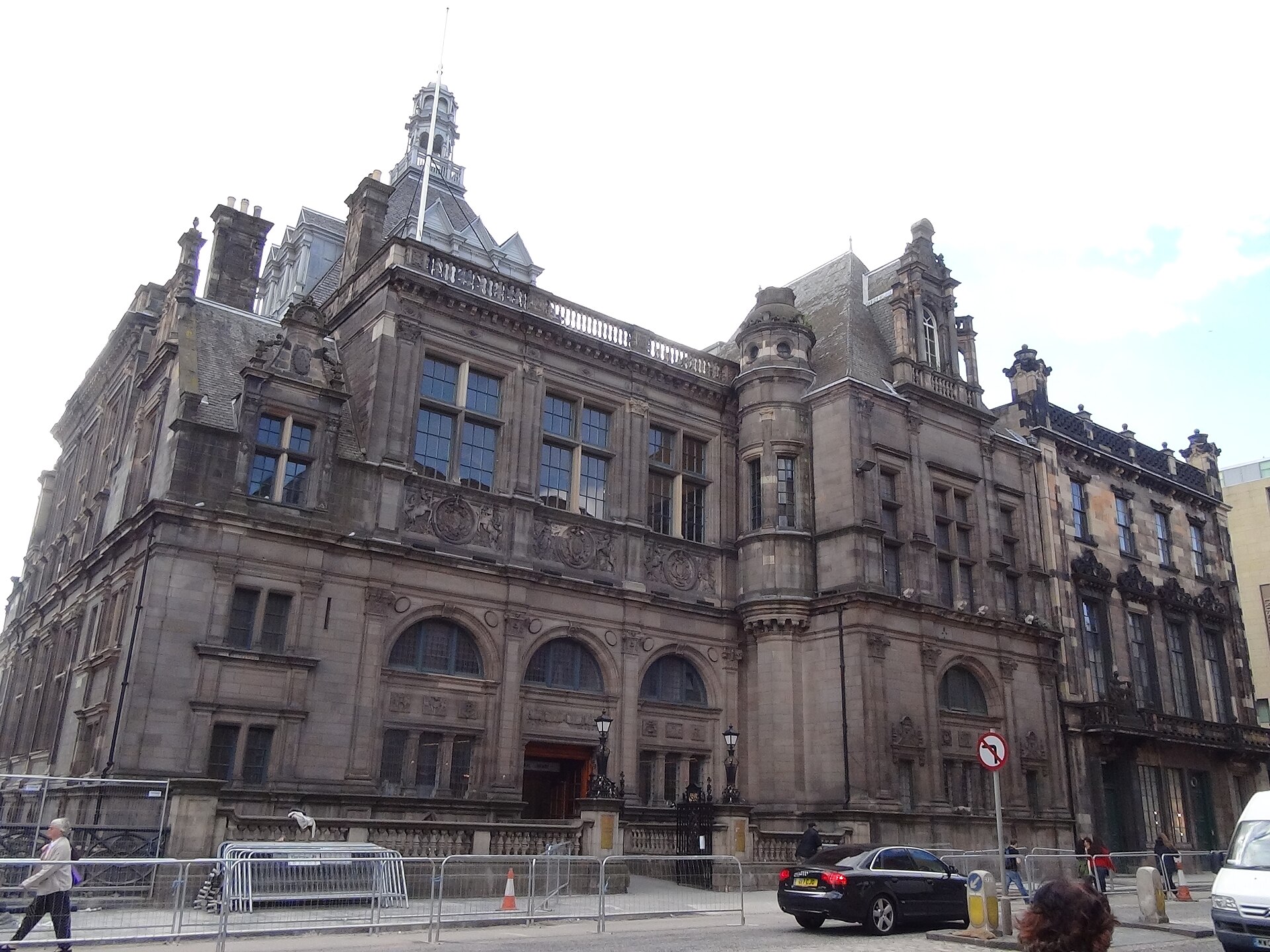 Edinburgh Central Library has an ornate stone facade, arched windows and a rounded turret overlooking the pavement.
