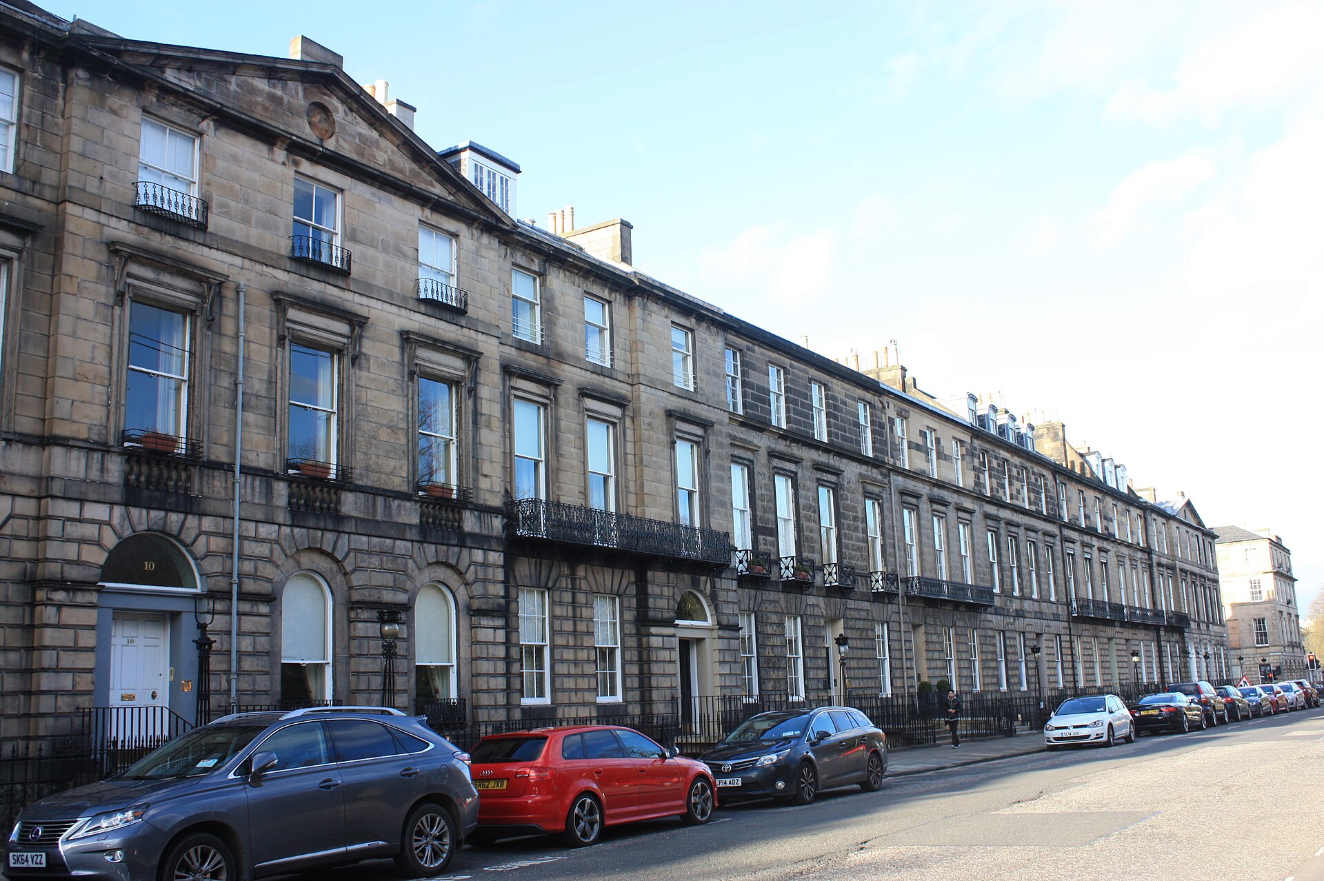 Georgian stone terraces line Heriot Row in Edinburgh New Town, with sash windows, iron balconies and parked cars.