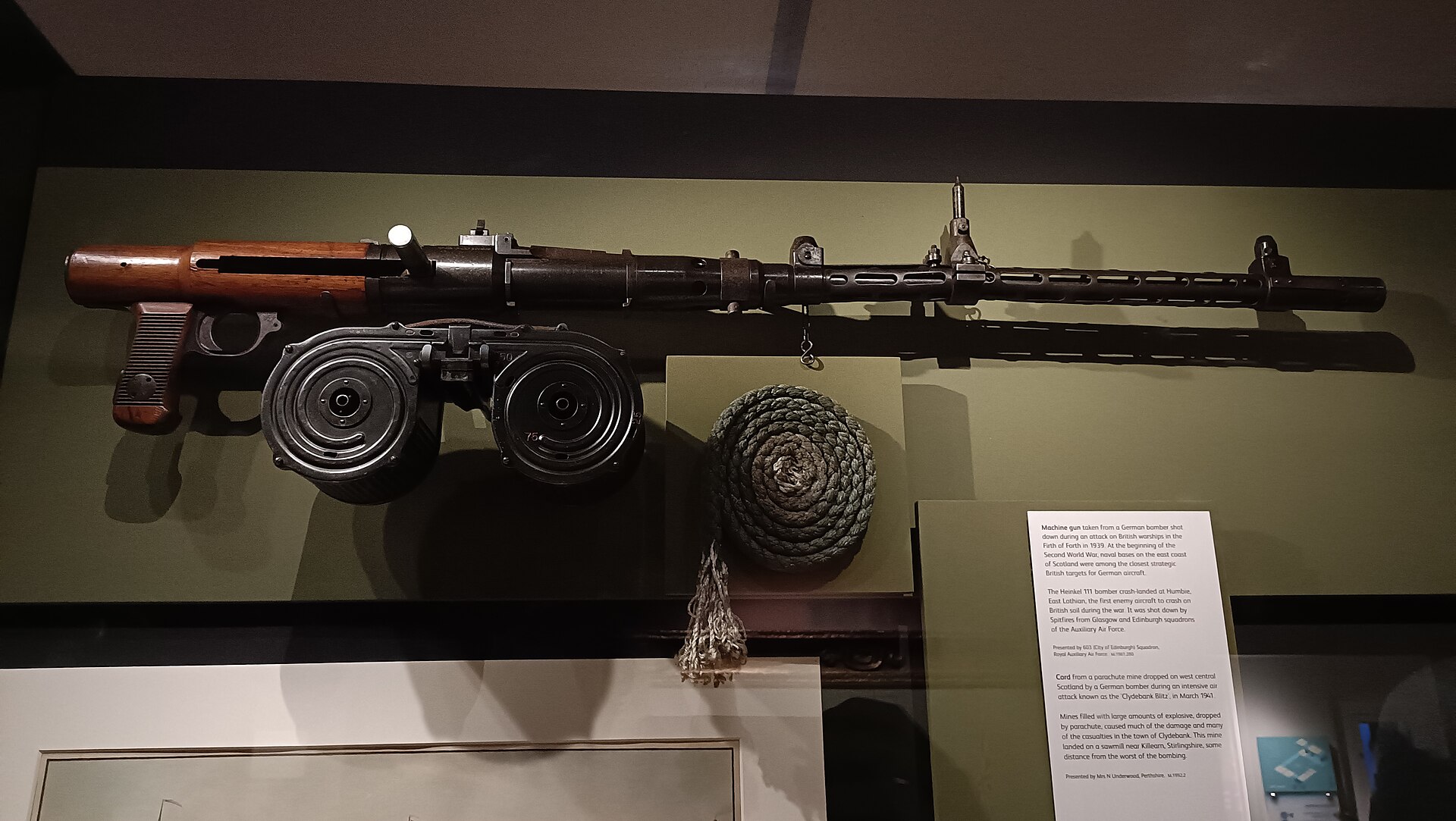 A machine gun with wooden stock and twin ammunition drums is mounted inside Edinburgh Castle's National War Museum.