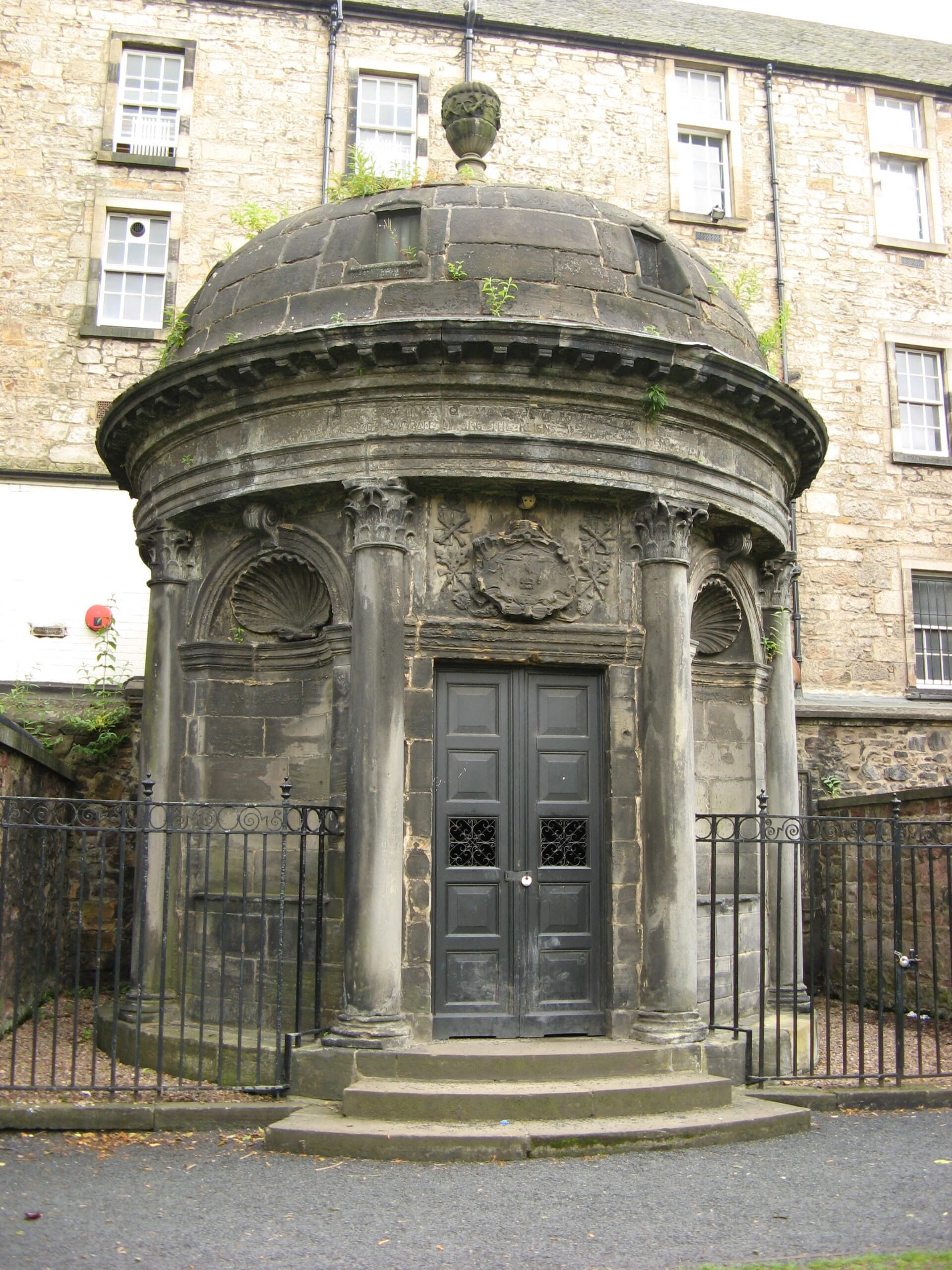 Sir George Mackenzie's domed mausoleum in Edinburgh's Greyfriars Kirkyard, with columns, closed doors and iron railings.