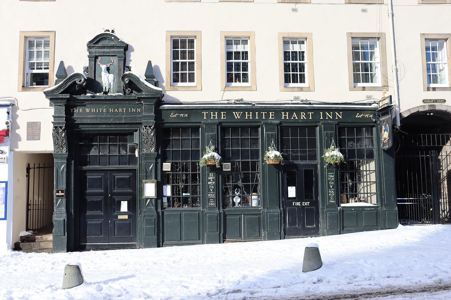 Snow covers the pavement outside the dark painted White Hart Inn frontage in Edinburgh's Grassmarket.
