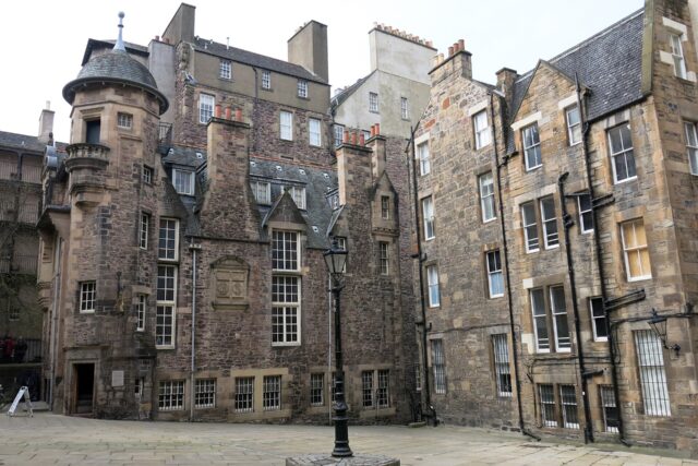 The turreted Writers' Museum faces a paved courtyard in Lady Stair's Close, Edinburgh, surrounded by tall stone buildings.