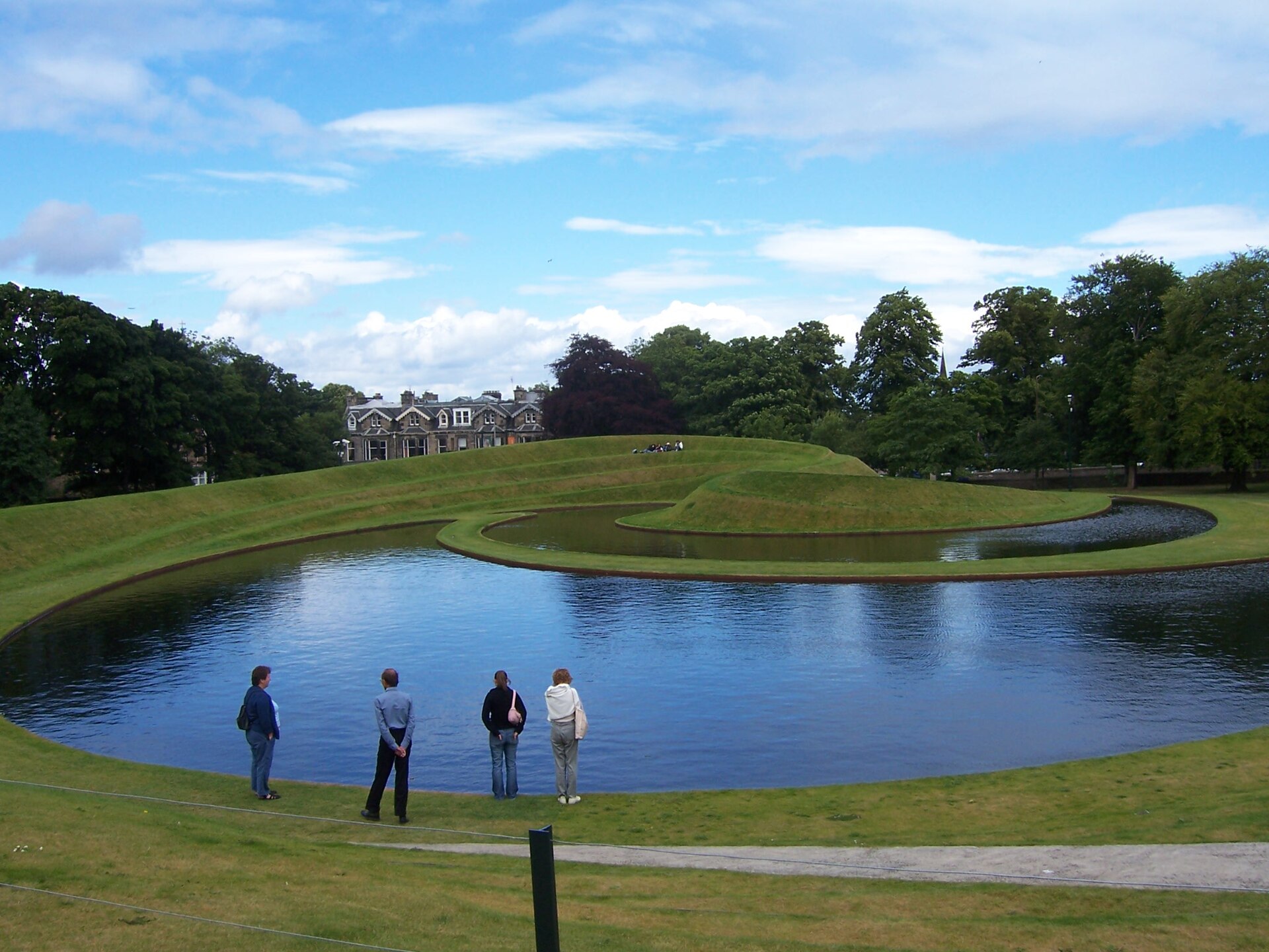 Visitors look across the curved pool towards Landform’s grassy terraces at the Scottish National Gallery of Modern Art in Edinburgh.